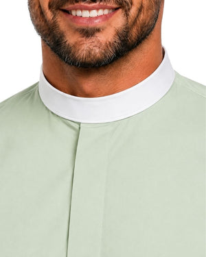 Close-up of a man wearing a light sage green clerical shirt with a contrasting white collar, cropped from the mouth down against a plain white background.