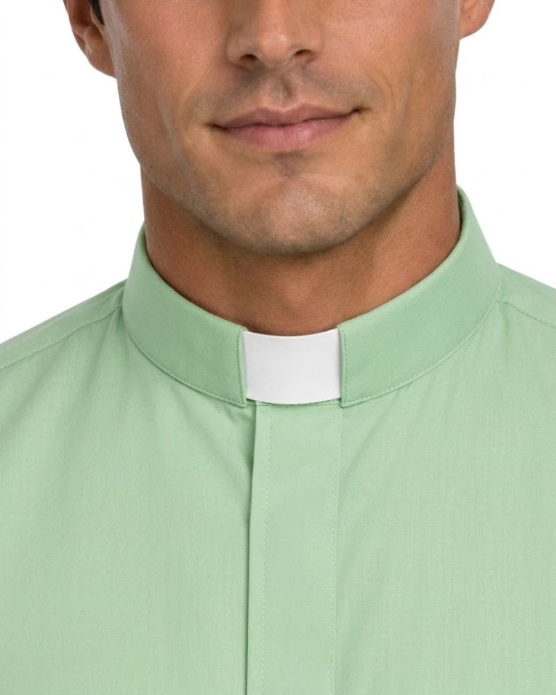 A close-up of a man wearing a light green clerical shirt with a white collar tab, shown from the lower face to the chest against a plain white background.