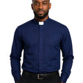A man wearing a navy blue long-sleeve clerical shirt with a white collar tab, paired with black trousers and a black belt, against a plain white background.
