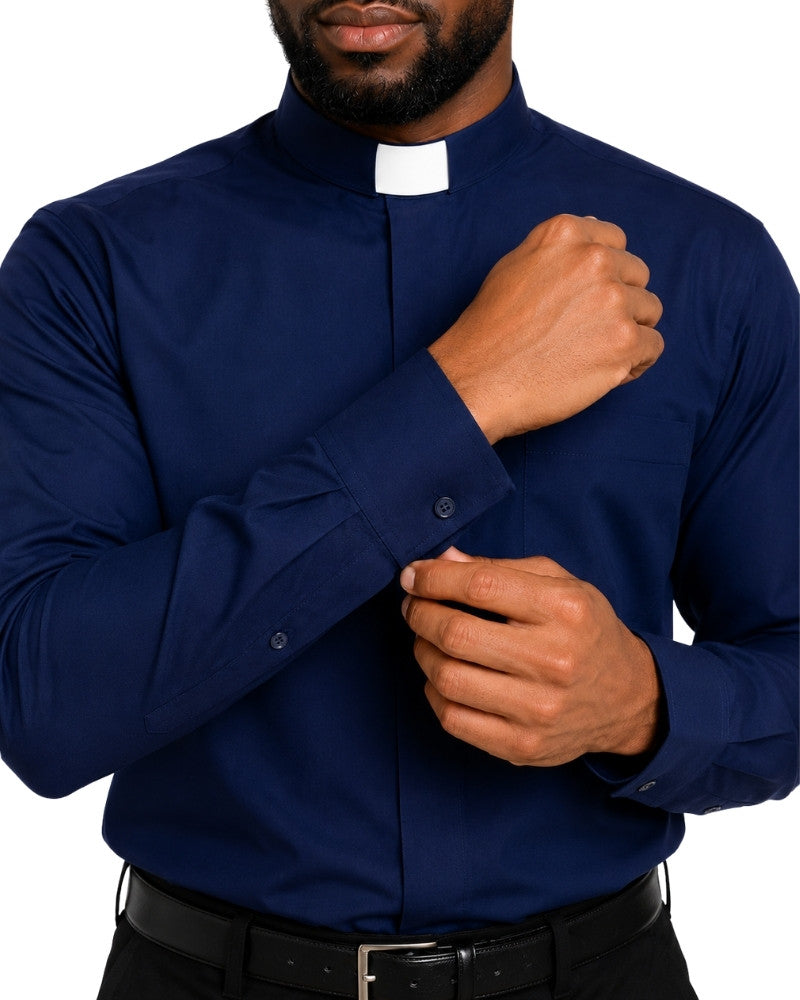 A man wearing a navy blue long-sleeve clerical shirt with a white clerical collar, adjusting the cuff with one hand while wearing a black belt.
