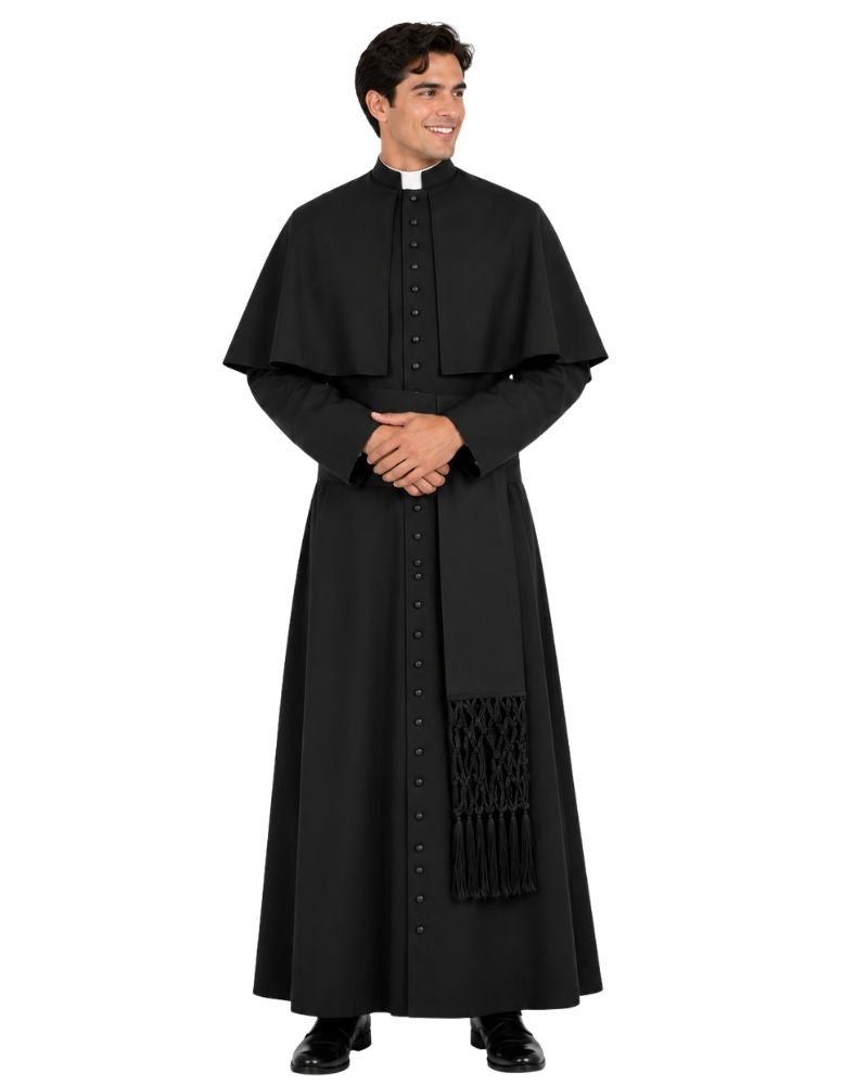 A man modeling a Obsidian Black Roman House Cassock with a high collar, long sleeves, and a decorative black tassel detail near the lower front, photographed against a plain white background.