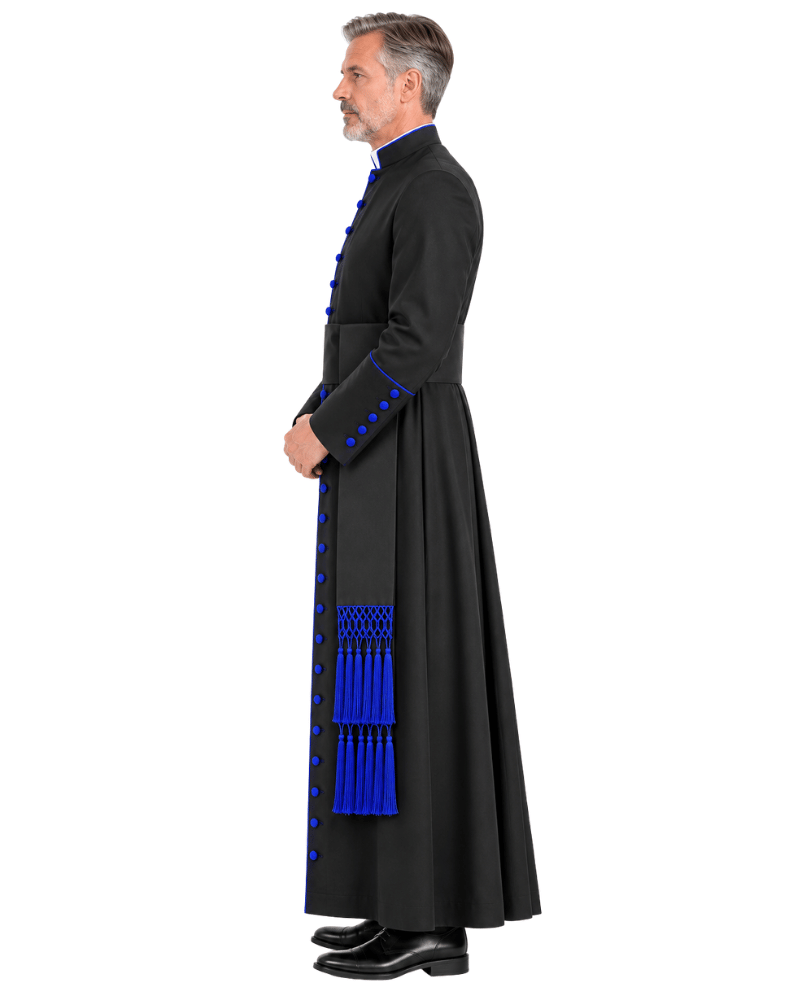 A man wearing a Obsidian Royal Blue Clerical Cassock with bright blue trim, decorative buttons, and a matching blue tassel detail at the hem, shown in profile against a plain white background.