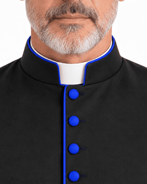 Close-up of a man wearing a Obsidian Royal Blue Clerical Cassock with bright blue trim and matching blue buttons, over a white collar, against a plain white background.
