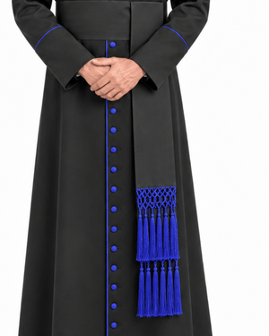 A close-up of a Obsidian Royal Blue Clerical Cassock with vivid royal blue trim, decorative buttons, and a matching blue tassel fringe detail on the front panel, shown on a plain white background.