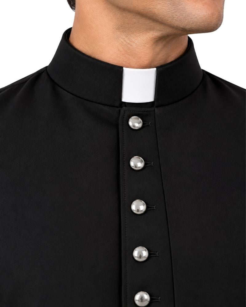 Close-up of a man wearing a black clerical cassock with a white collar and silver buttons down the front, against a plain white background.
