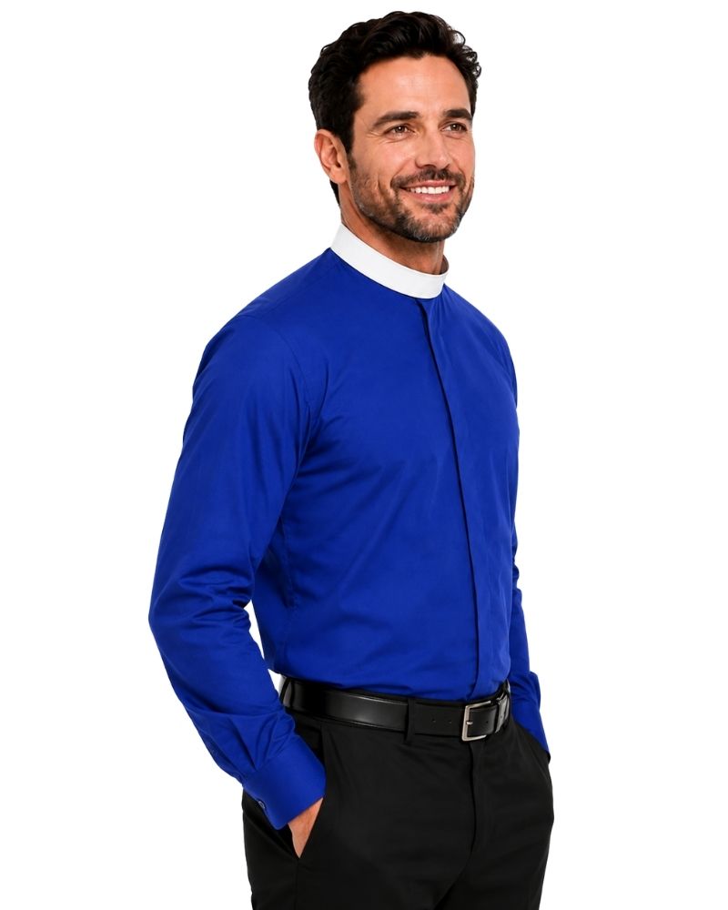 A smiling man wearing a royal blue long-sleeve clerical shirt with a white collar, paired with black trousers and a black belt, photographed against a solid white background.