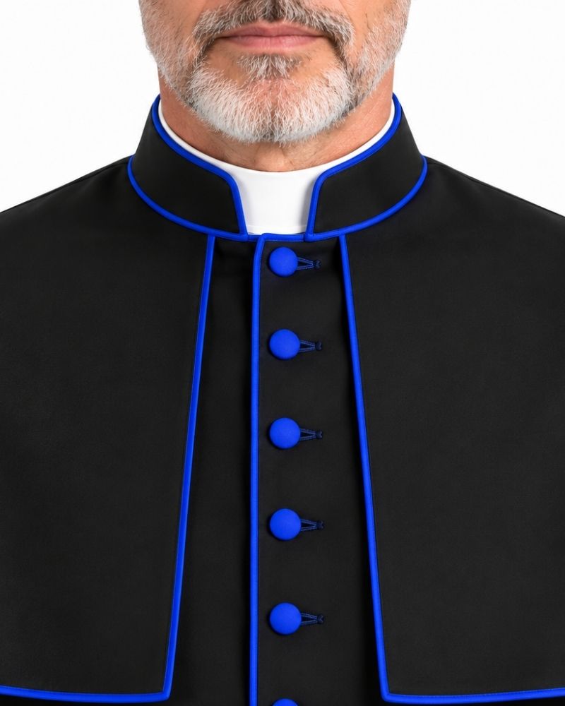 A close-up of a man wearing a Traditional Clerical Cassock With Blue Trim with bright blue piping and matching blue buttons, over a white collar, against a plain white background.