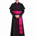A man modeling a Traditional Clerical Cassock With Magenta Trim with vibrant pink trim, a pink waist sash, and a pink dalmatic, set against a plain white background.