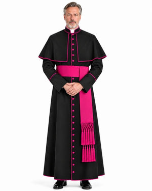 A man modeling a Traditional Clerical Cassock With Magenta Trim with vibrant pink trim, a pink waist sash, and a pink dalmatic, set against a plain white background.