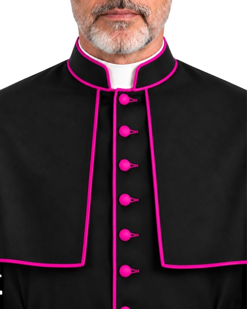 A close-up of a man wearing a Traditional Clerical Cassock With Magenta Trim with bright pink piping and matching pink buttons, over a white collar, against a plain white background.