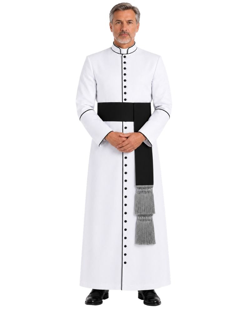 A man modeling a White And Black Clergy Robe, a wide black waist sash, and a gray-and-white tasseled hanging detail, shown against a plain white background.