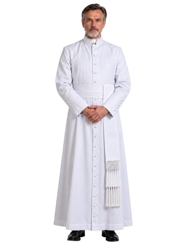 A man wearing a White Clergy Cassock with a high collar, front buttons, a waist belt, and a decorative white sash with fringe, standing against a plain white background.