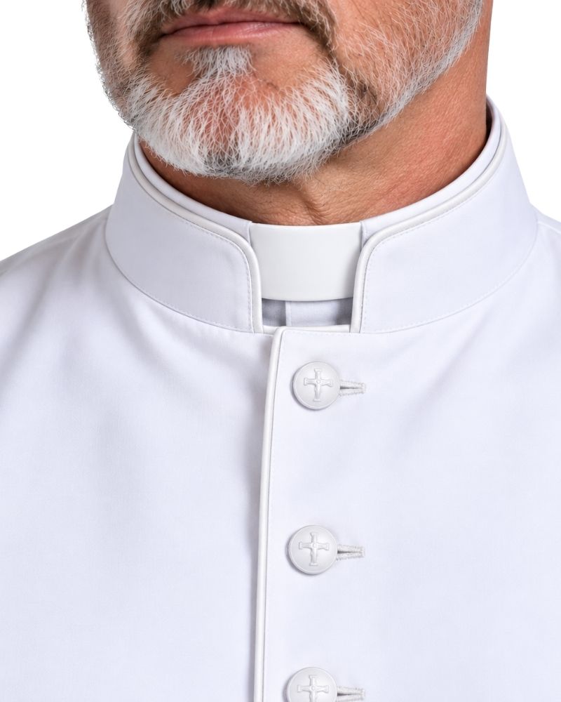 Close-up of a man wearing a White Clergy Cassock and white shirt with decorative buttons, against a plain white background.
