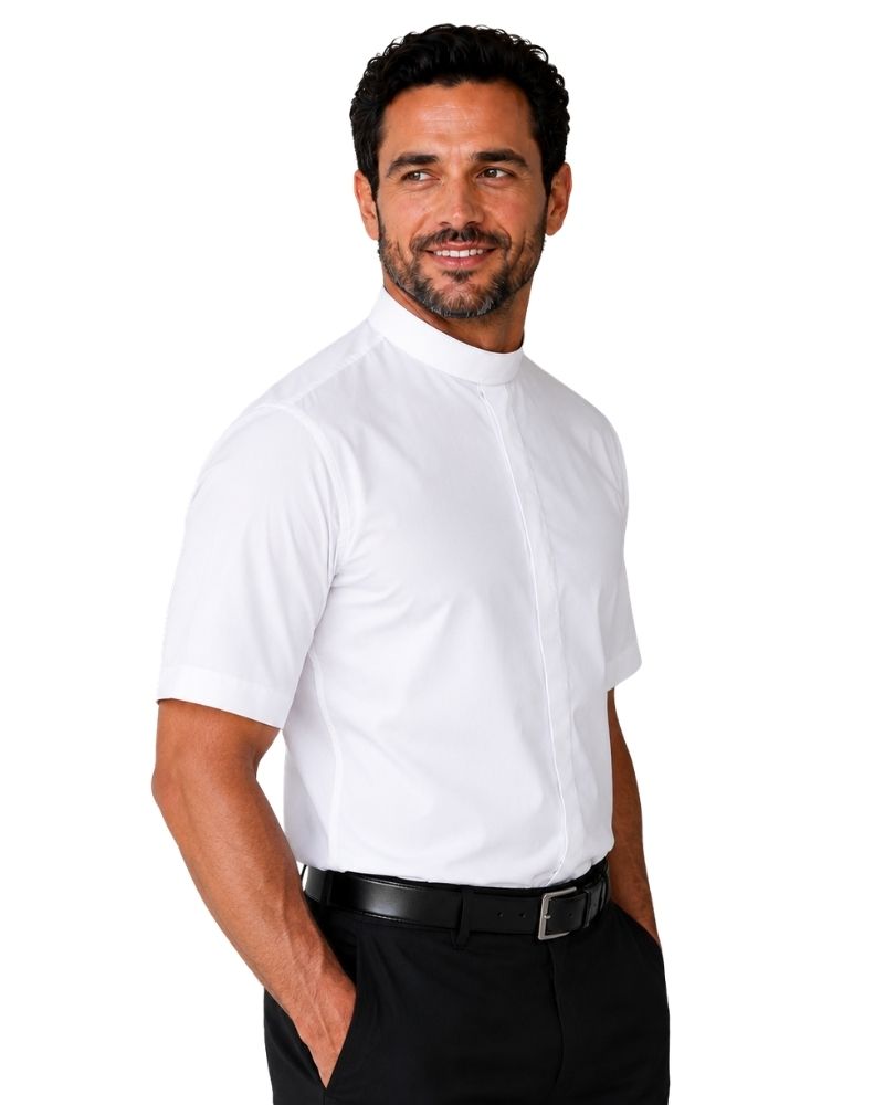 A man wearing a white short-sleeve clerical shirt with a high mock neck collar, paired with black trousers and a black belt, photographed against a solid white background.