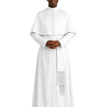 A man wearing a white priestly habit and matching white stole with decorative fringe, standing against a plain white background.
