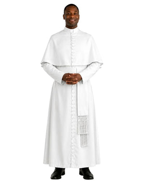 A man wearing a white priestly habit and matching white stole with decorative fringe, standing against a plain white background.