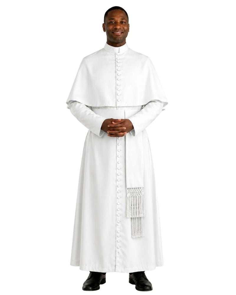 A man wearing a white priestly habit and matching white stole with decorative fringe, standing against a plain white background.