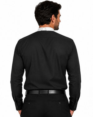A man viewed from the back wearing a black long-sleeve clerical shirt, black trousers, and a black belt, with a white shirt collar peeking out at the neck. The photo is shot against a solid white background.