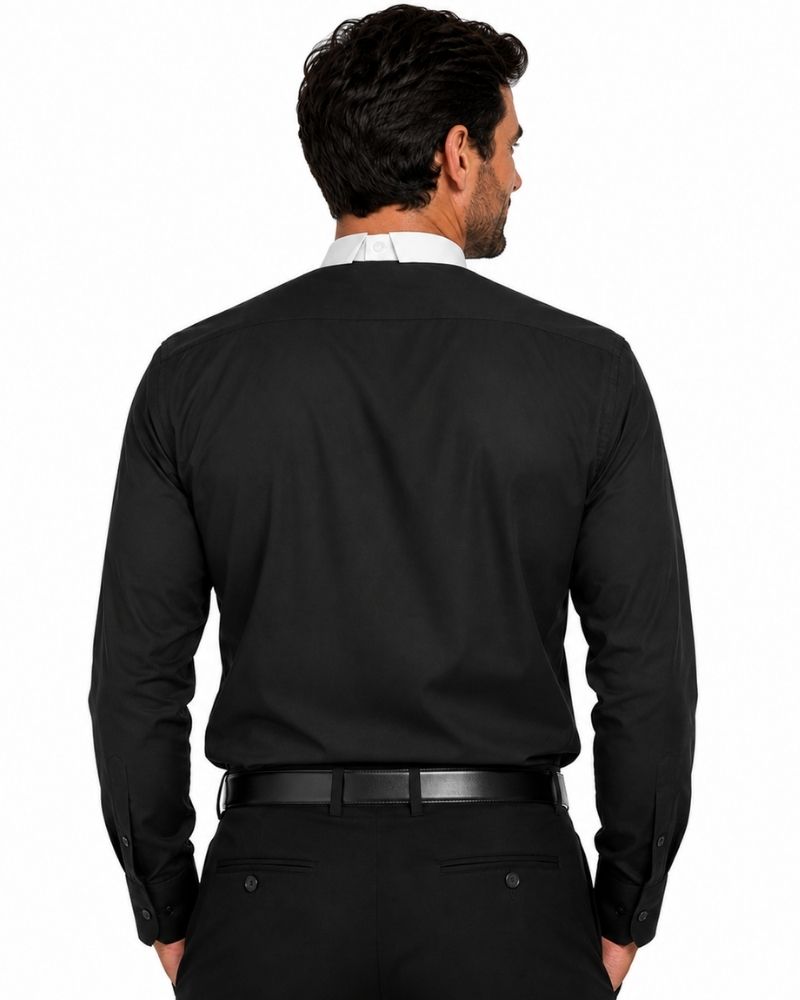 A man viewed from the back wearing a black long-sleeve clerical shirt, black trousers, and a black belt, with a white shirt collar peeking out at the neck. The photo is shot against a solid white background.