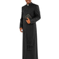 A man modeling a long black clerical robe with a high collar, front buttons, and a matching black fringed scarf, holding a small book against a plain white background.