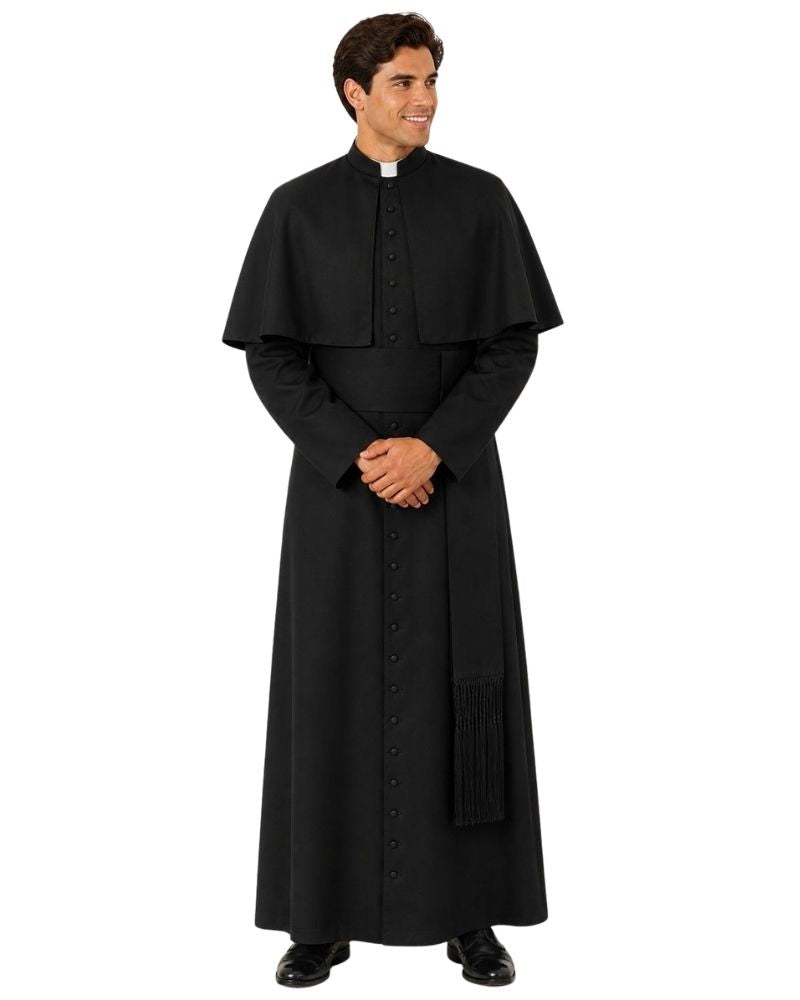 A man modeling a black priestly  robe with a collar, standing against a plain white background.