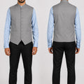 Man wearing a gray vest over a light blue shirt with black pants, shown from front and back.