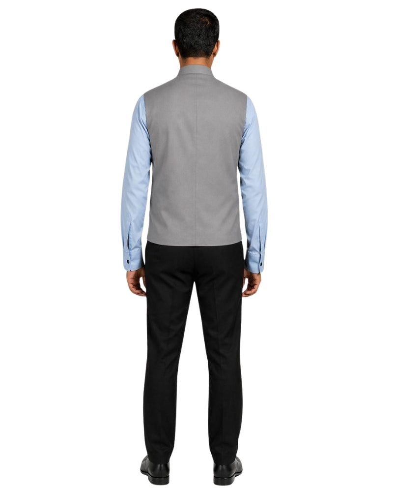Man wearing a gray vest over a light blue shirt on a white background.