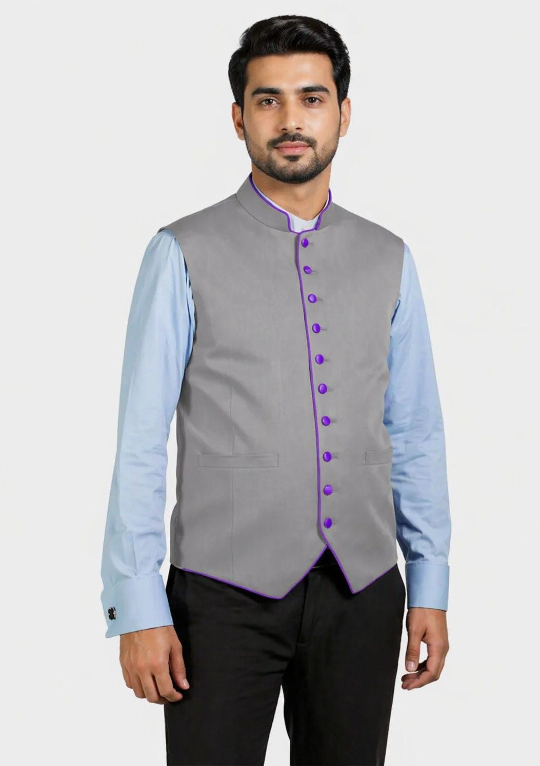 Man wearing a gray vest with purple buttons over a light blue shirt on a white background