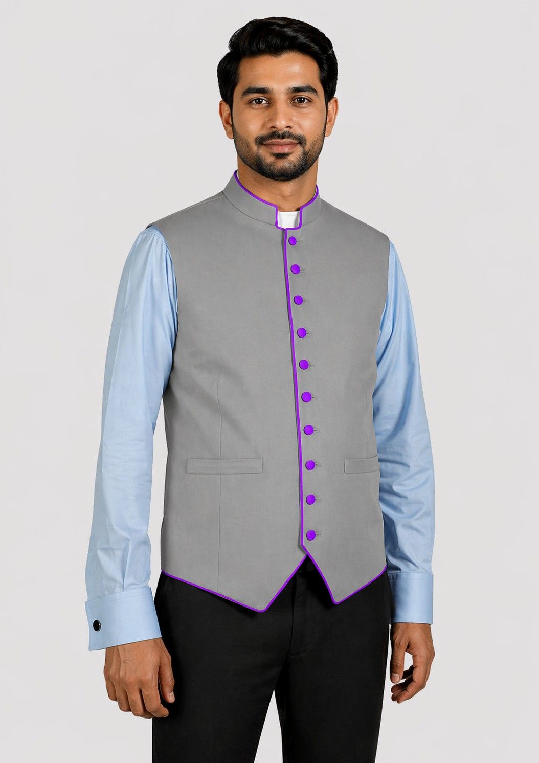 Man wearing a gray vest with purple buttons over a light blue shirt on a white background