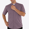 Man wearing a gray clerical shirt with a white collar on a white background