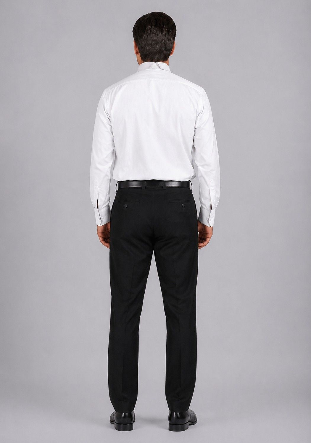 Man wearing a white dress shirt and black pants on a gray background