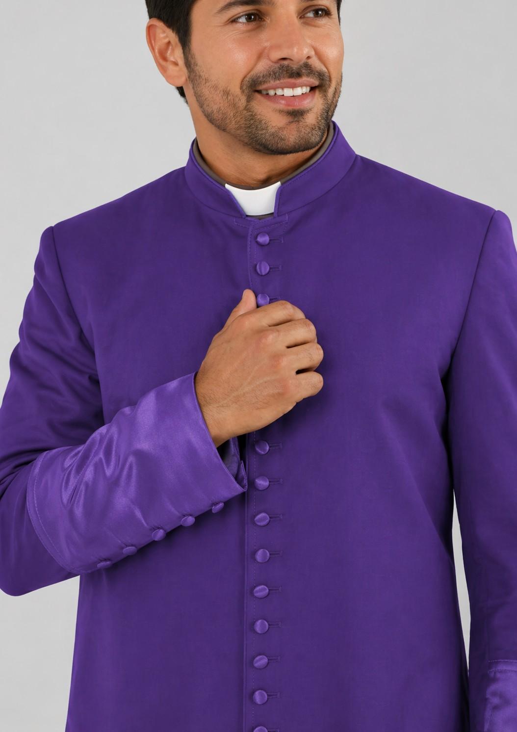 Man wearing a purple clerical robe against a gray background