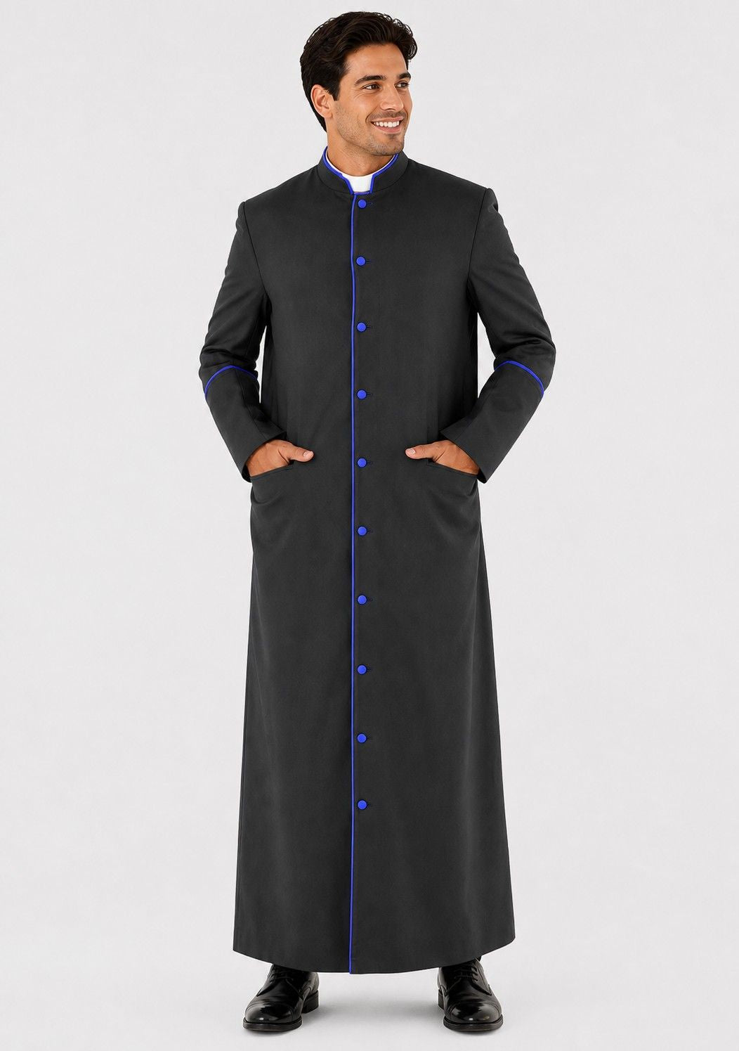 Man wearing a long black coat with blue buttons on a white background