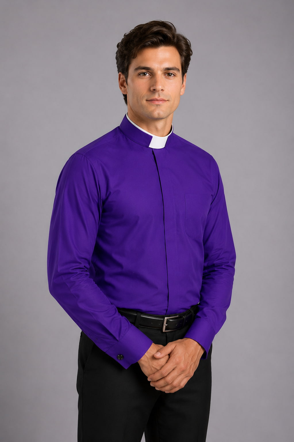Man wearing a purple shirt with a clerical collar against a gray background