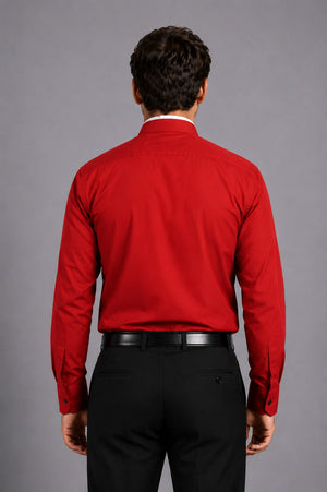 Men wearing a red shirt and black pants against a gray background