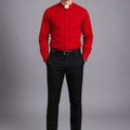 Man wearing a red shirt and black pants on a gray background
