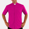 Man wearing a bright pink clerical shirt with a white collar on a white background