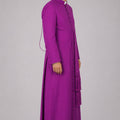 Man wearing a purple robe on a gray background