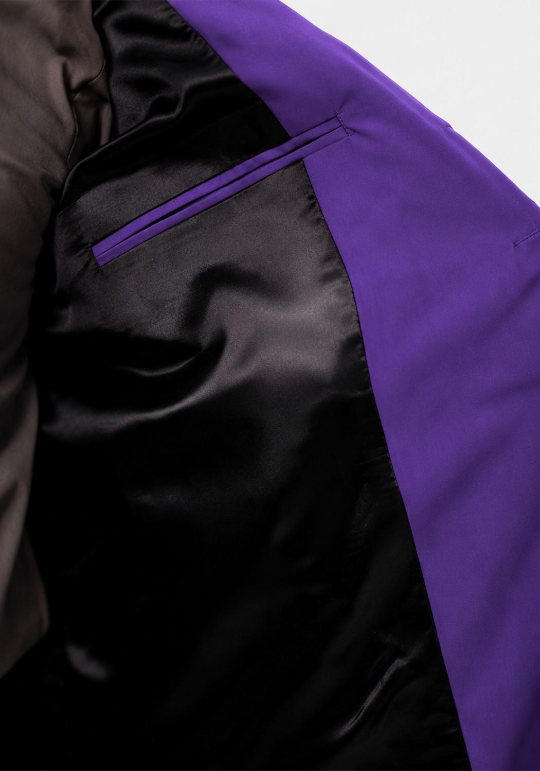 Close-up of a black jacket with purple zipper and trim on a white background