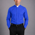 Man wearing a blue clerical shirt with a white collar against a gray background
