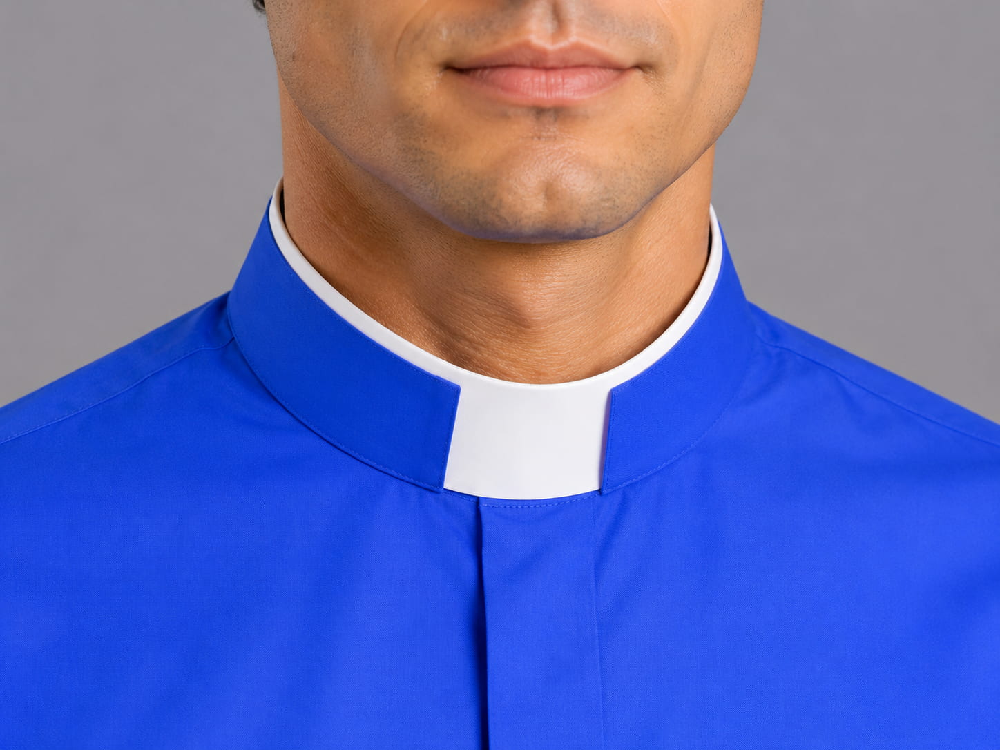 Blue clerical shirt with white collar against a gray background