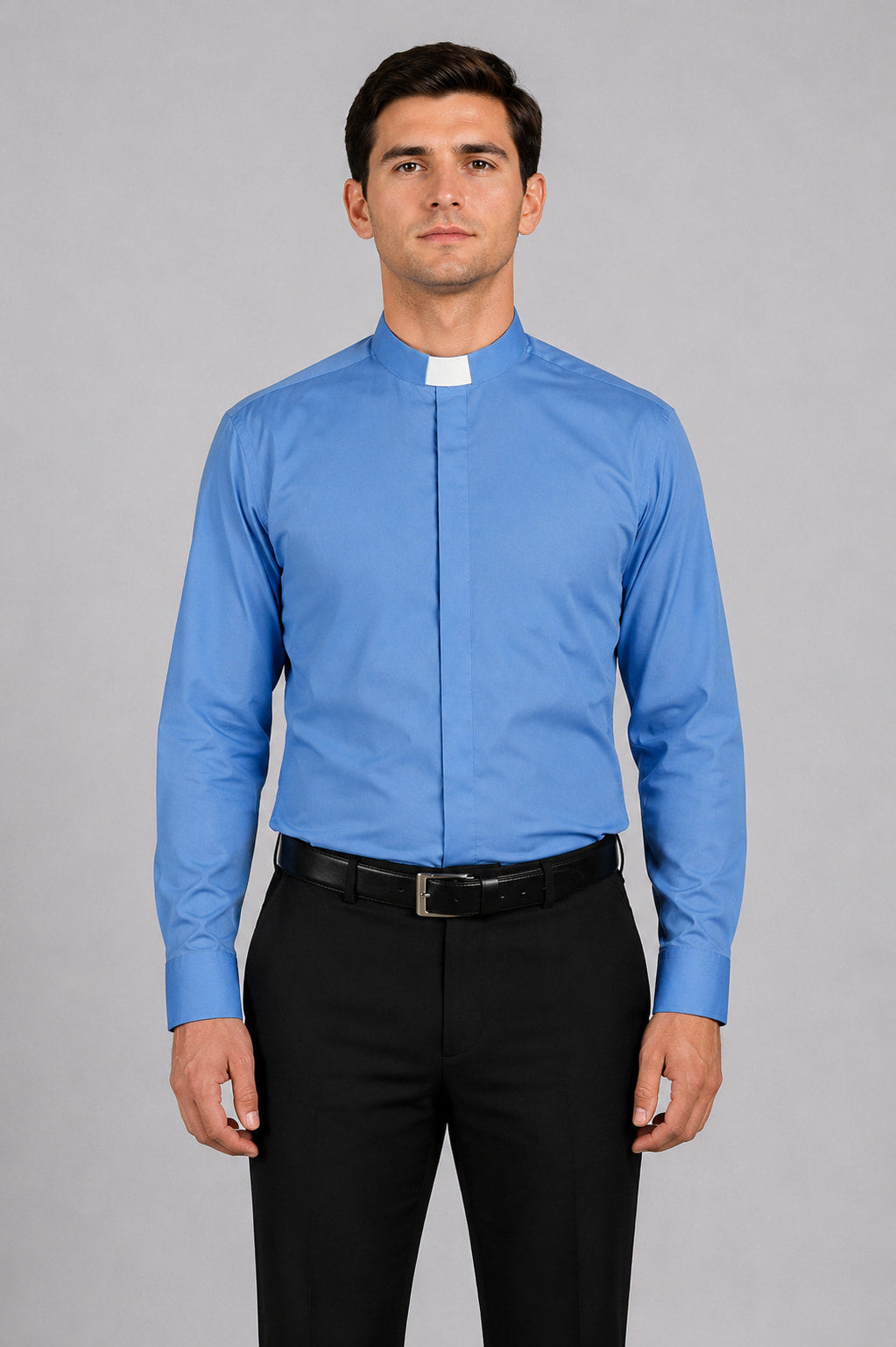 Man wearing a blue clerical shirt with a white collar against a gray background