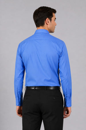 Man wearing a blue dress shirt and black pants on a gray background
