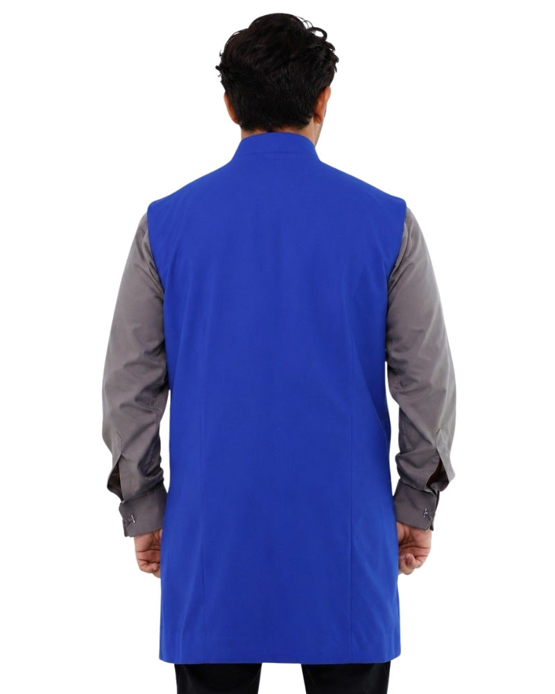 Man wearing a blue vest over a gray shirt on a white background