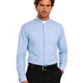 Man wearing a light blue long-sleeve shirt with a collar on a white background