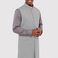 Man wearing a gray vest over a shirt on a white background