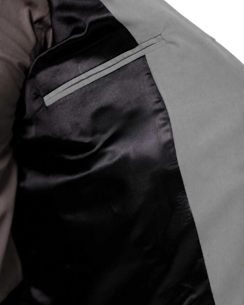 Man wearing a gray vest over a shirt on a white background