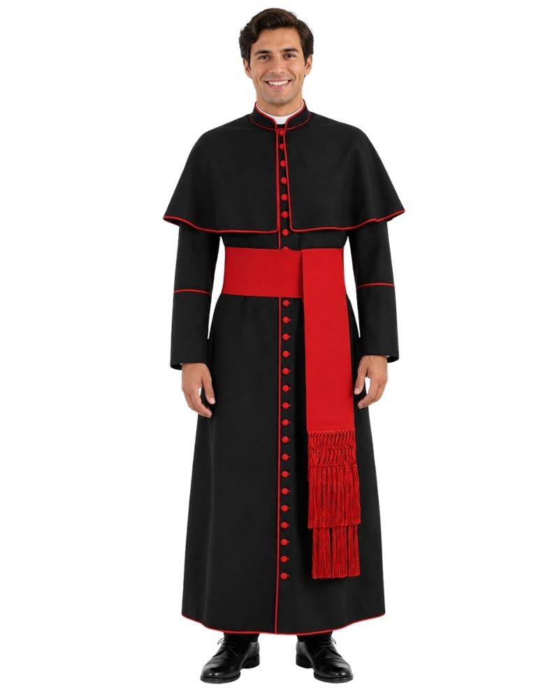 A man modeling a black and red papal or clerical cassock with a red sash and red trim, standing against a plain white background.