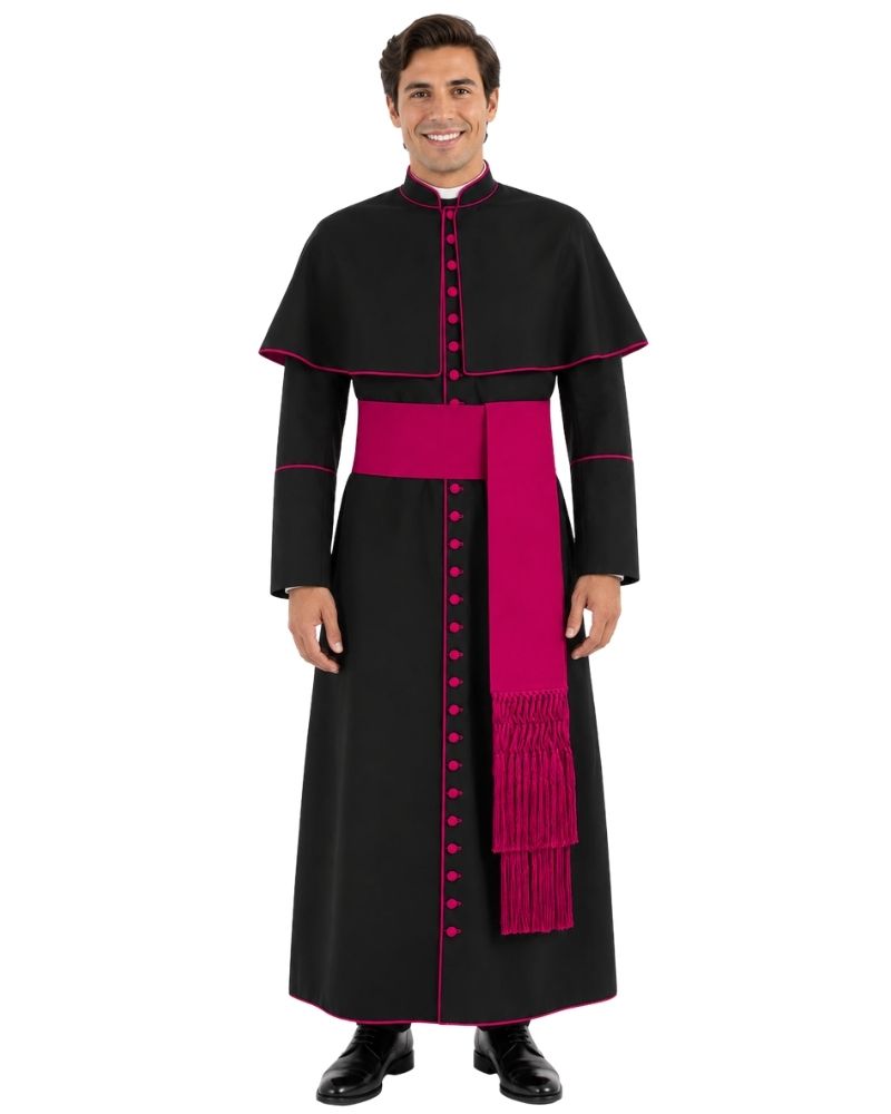 A man modeling a black papal collar and long robe with a bright pink sash and trim, set against a plain white background.