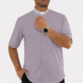 Man wearing a gray clergy shirt with a white collar on a white background